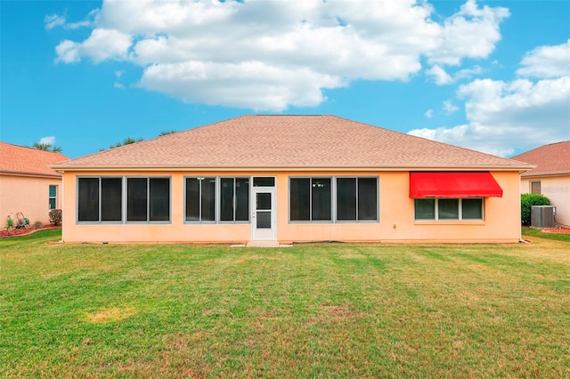 back of house featuring a shingled roof, central AC, a yard, and stucco siding