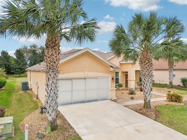 view of front of property with stucco siding, a front yard, a garage, cooling unit, and driveway