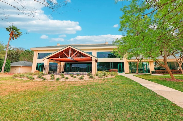 view of front of house with a front lawn, fence, and stucco siding