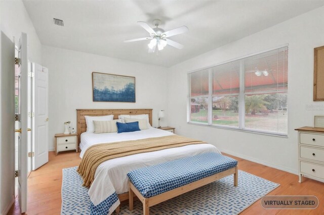 bedroom with ceiling fan, light wood finished floors, visible vents, and baseboards