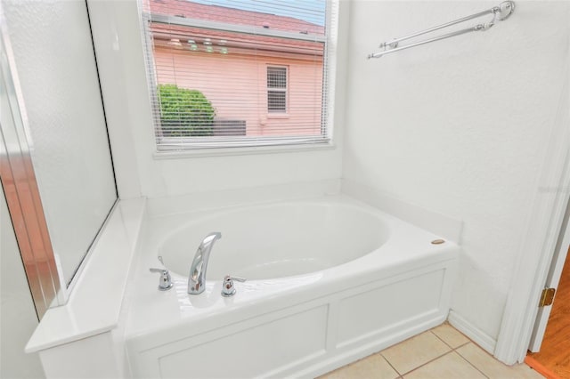 bathroom with a bath and tile patterned floors