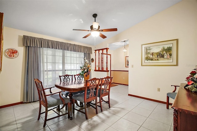 dining room with a ceiling fan, lofted ceiling, baseboards, and light tile patterned floors