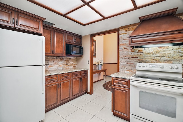 kitchen with white appliances, light tile patterned floors, light stone counters, custom exhaust hood, and backsplash