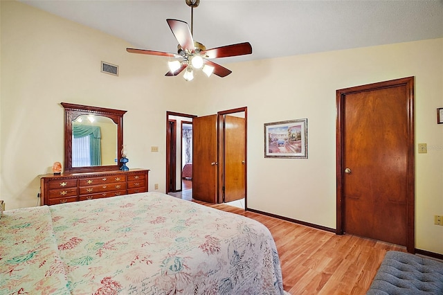 bedroom with light wood-type flooring, baseboards, visible vents, and ceiling fan