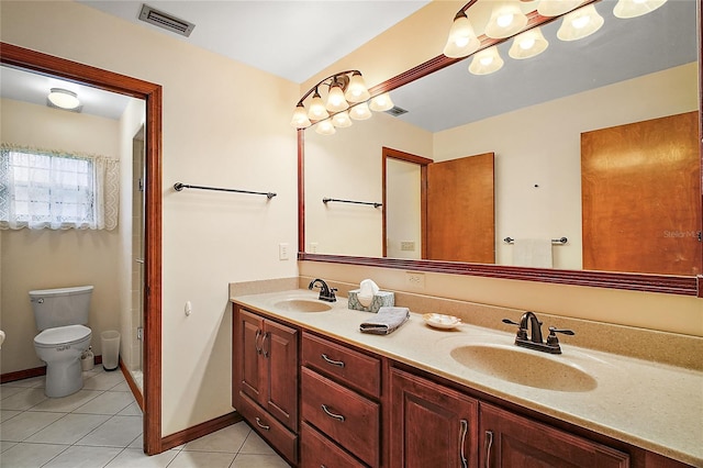 bathroom featuring toilet, a sink, visible vents, and tile patterned floors