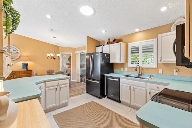 kitchen with white cabinets, lofted ceiling, black appliances, pendant lighting, and a sink