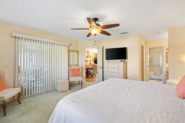 bedroom featuring a textured ceiling, ceiling fan, ensuite bathroom, carpet floors, and visible vents