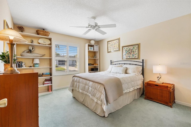 carpeted bedroom featuring a textured ceiling, ceiling fan, and baseboards