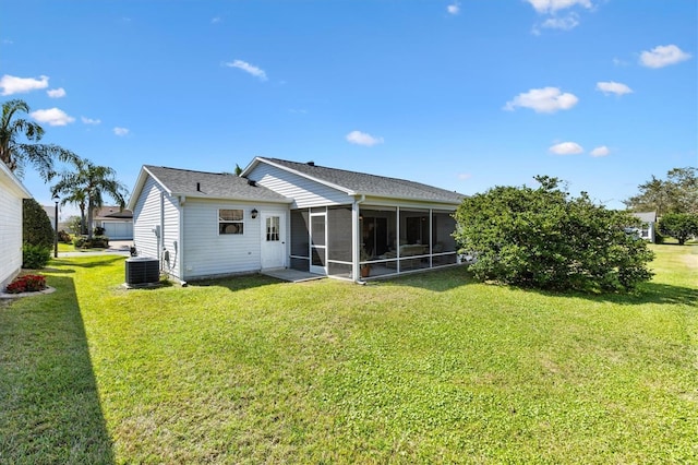 back of house with cooling unit, a sunroom, and a lawn