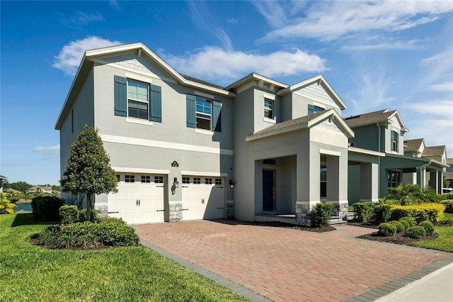 view of front of home with a garage, stone siding, decorative driveway, and stucco siding