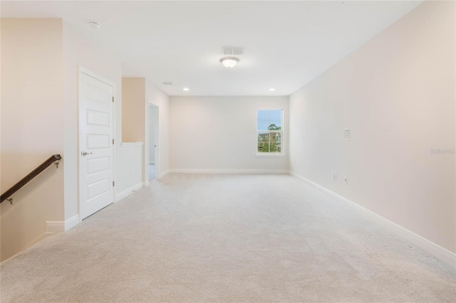 spare room featuring light carpet, baseboards, and visible vents