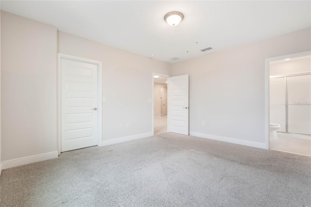 unfurnished bedroom with carpet, visible vents, baseboards, and connected bathroom