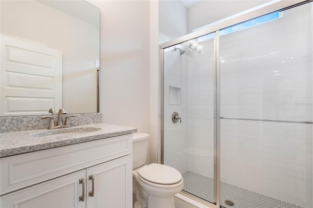 full bathroom featuring toilet, a stall shower, and vanity