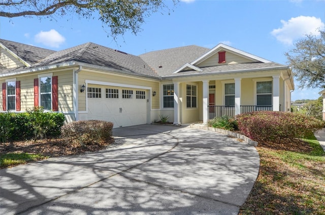 view of front of home with a garage, covered porch, a shingled roof, and concrete driveway