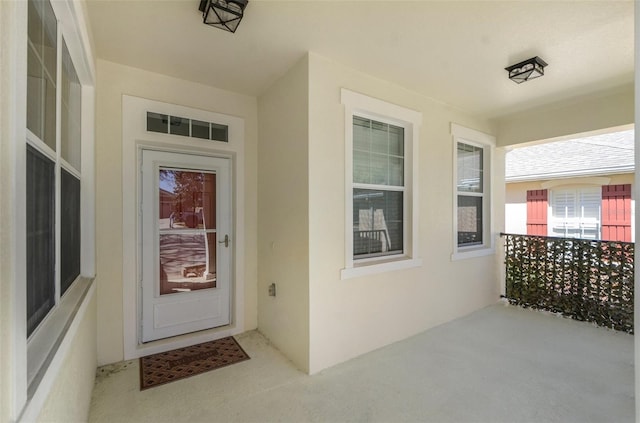 doorway to property featuring visible vents and stucco siding