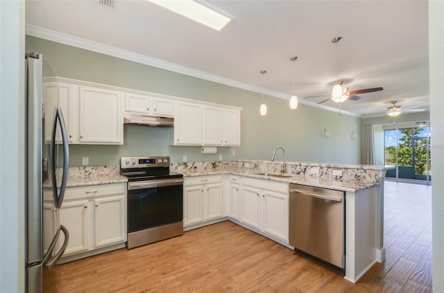 kitchen with under cabinet range hood, a peninsula, a sink, ornamental molding, and appliances with stainless steel finishes