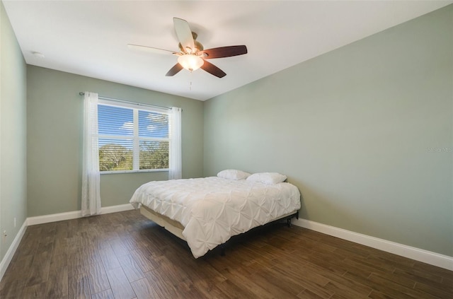 bedroom with wood finished floors, a ceiling fan, and baseboards