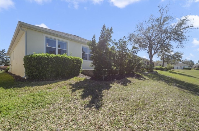 view of side of property with a yard and stucco siding