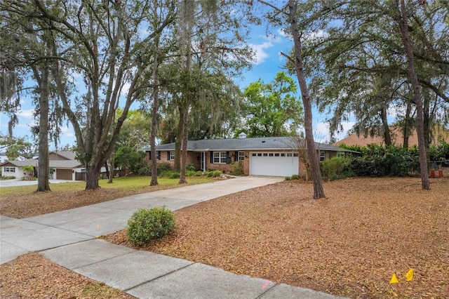 ranch-style house with concrete driveway, brick siding, and an attached garage