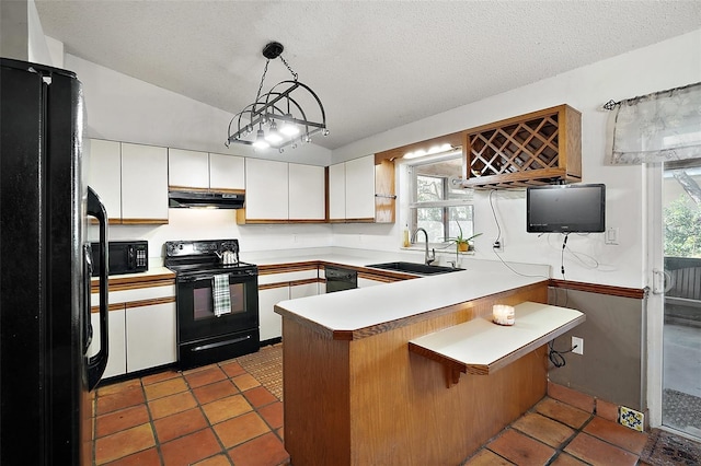 kitchen with range hood, white cabinetry, a sink, a peninsula, and black appliances