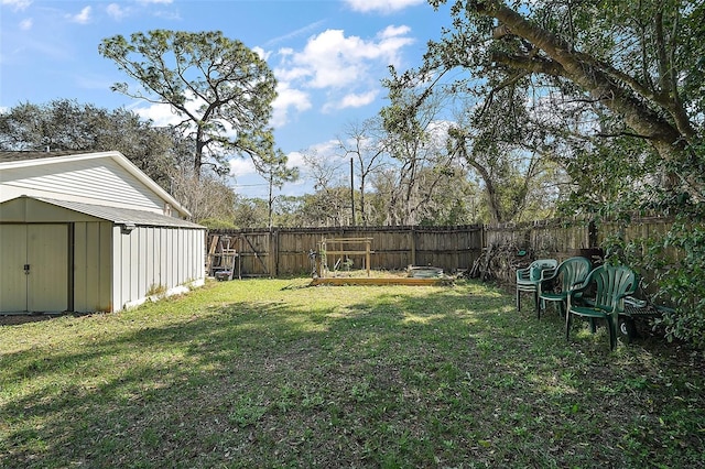 view of yard featuring a fenced backyard, a storage unit, and an outbuilding