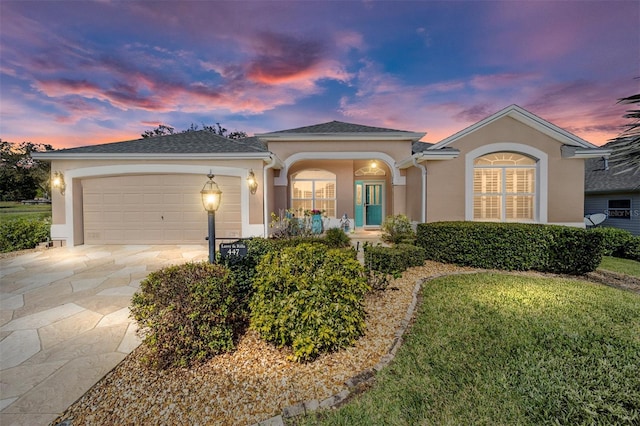 view of front facade with a garage, concrete driveway, and stucco siding