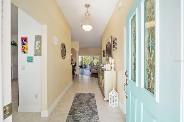 hallway with light tile patterned floors and baseboards