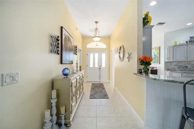 entryway with light tile patterned floors, visible vents, and baseboards