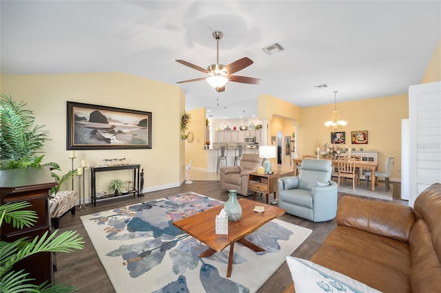 living area featuring lofted ceiling, ceiling fan with notable chandelier, wood finished floors, visible vents, and baseboards