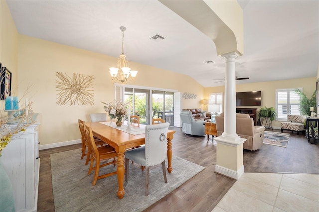 dining room featuring ceiling fan with notable chandelier, wood finished floors, visible vents, and ornate columns