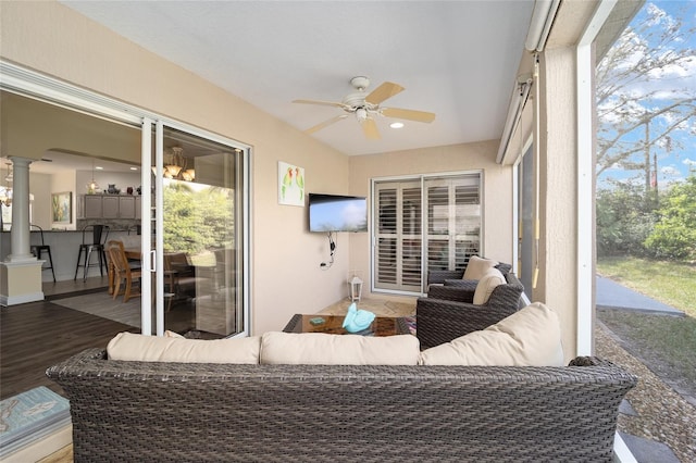 sunroom / solarium featuring ceiling fan and ornate columns