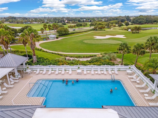 community pool featuring fence, golf course view, and a patio