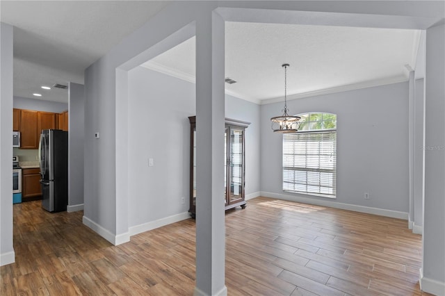 3430 Turningwind Ln, Winter Garden, FL 34787 - unfurnished living room featuring a chandelier, light wood-type flooring, baseboards, and crown molding