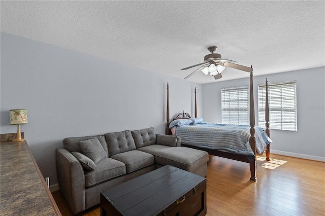 3430 Turningwind Ln, Winter Garden, FL 34787 - bedroom featuring light wood finished floors, a textured ceiling, baseboards, and ceiling fan