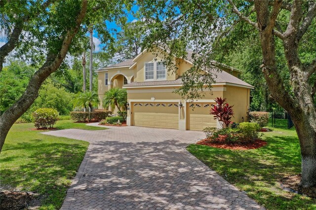 3430 Turningwind Ln, Winter Garden, FL 34787 - view of front of home with stucco siding, decorative driveway, a front yard, and a garage