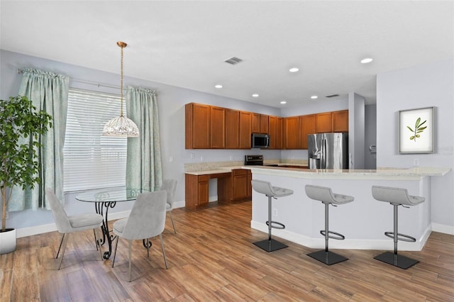 3430 Turningwind Ln, Winter Garden, FL 34787 - kitchen with appliances with stainless steel finishes, baseboards, light wood-style floors, a kitchen bar, and recessed lighting