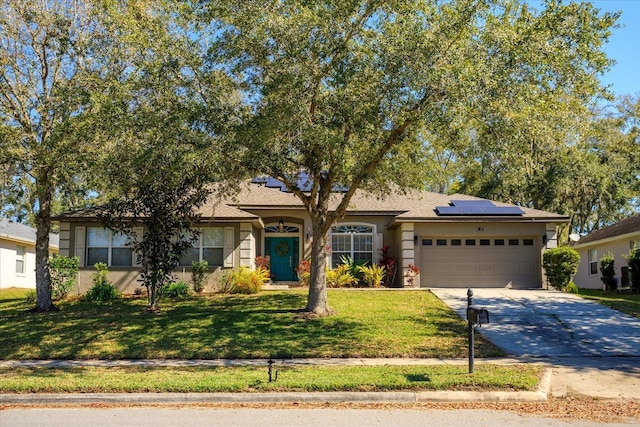 ranch-style home featuring stucco siding, a front yard, roof mounted solar panels, a garage, and driveway