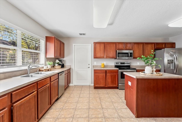 kitchen with light tile patterned floors, visible vents, stainless steel appliances, light countertops, and a sink