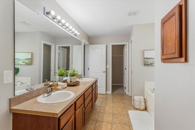 full bath with double vanity, tile patterned flooring, a sink, and a bath