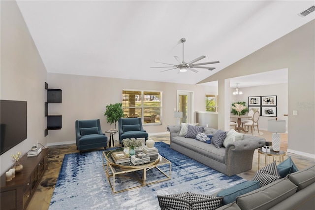 living area featuring visible vents, vaulted ceiling, baseboards, and ceiling fan with notable chandelier