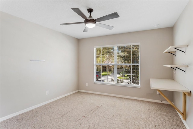 empty room with carpet floors, ceiling fan, and baseboards