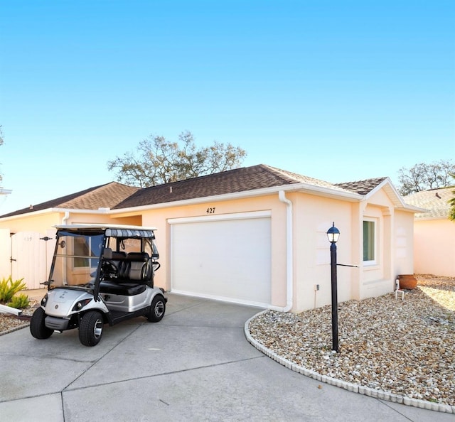 view of side of property featuring stucco siding, concrete driveway, a garage, and roof with shingles