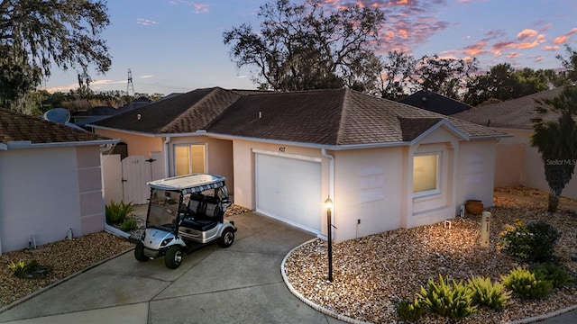 exterior space with a garage, roof with shingles, concrete driveway, and stucco siding