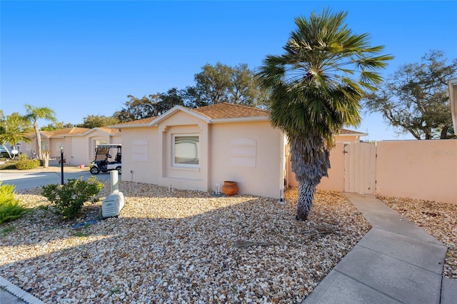 view of property exterior featuring stucco siding and a gate