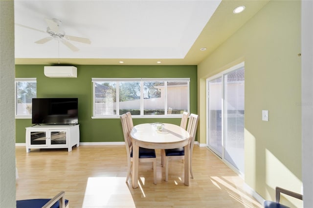 dining room with light wood finished floors, baseboards, an AC wall unit, recessed lighting, and a ceiling fan