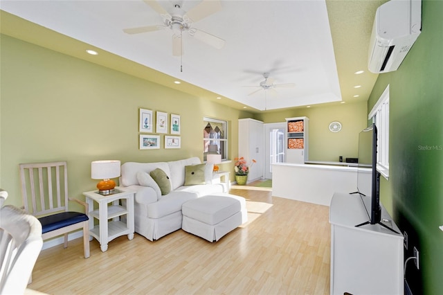 living room with an AC wall unit, recessed lighting, light wood-type flooring, and a raised ceiling