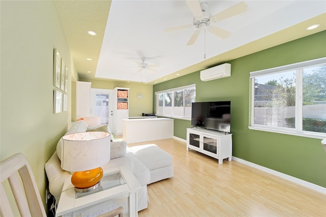 living room featuring baseboards, a wall mounted air conditioner, light wood-type flooring, recessed lighting, and a ceiling fan