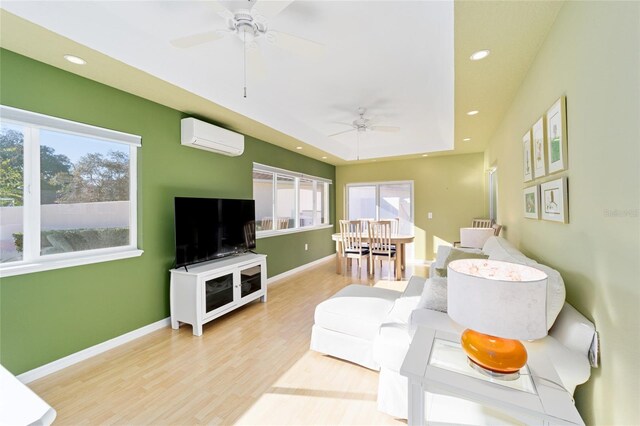 living room featuring a wall mounted air conditioner, baseboards, wood finished floors, and recessed lighting