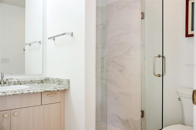 bathroom with a marble finish shower, toilet, and vanity