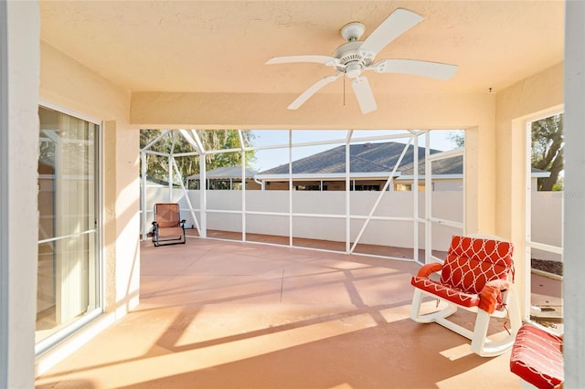 unfurnished sunroom featuring ceiling fan